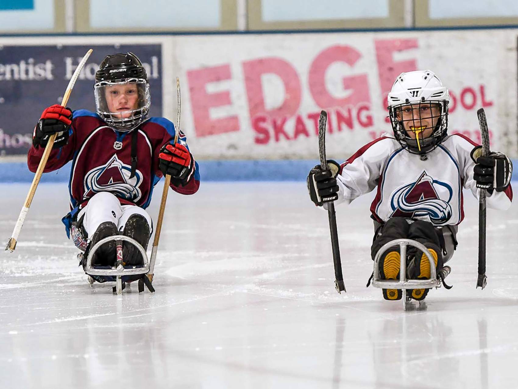 two children playing sled hockey