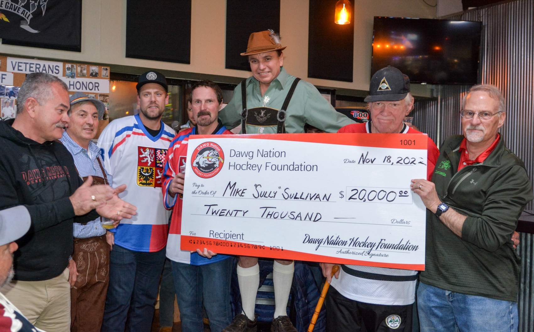 sully holding a check from dawgnation