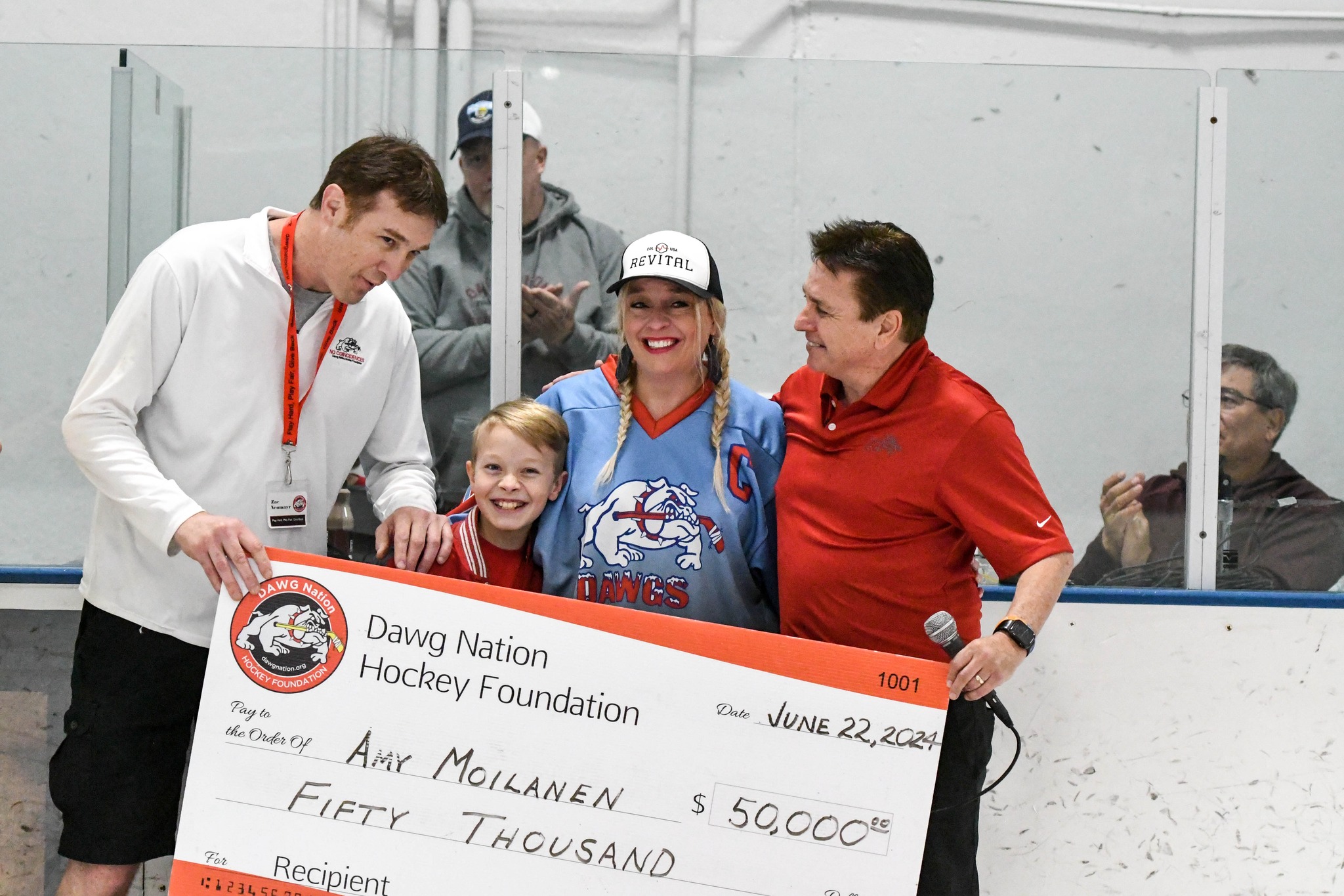 Amy Moilanen receiving a check from dawg nation
