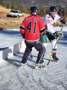 man in give back hockey jersey playing hockey